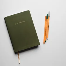 green book with pencils on white table related to Sage Green Coverlet: A Comprehensive Guide