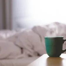 green ceramic mug on wooden desk related to Steep into Slumber: The Best Tea Before Bed