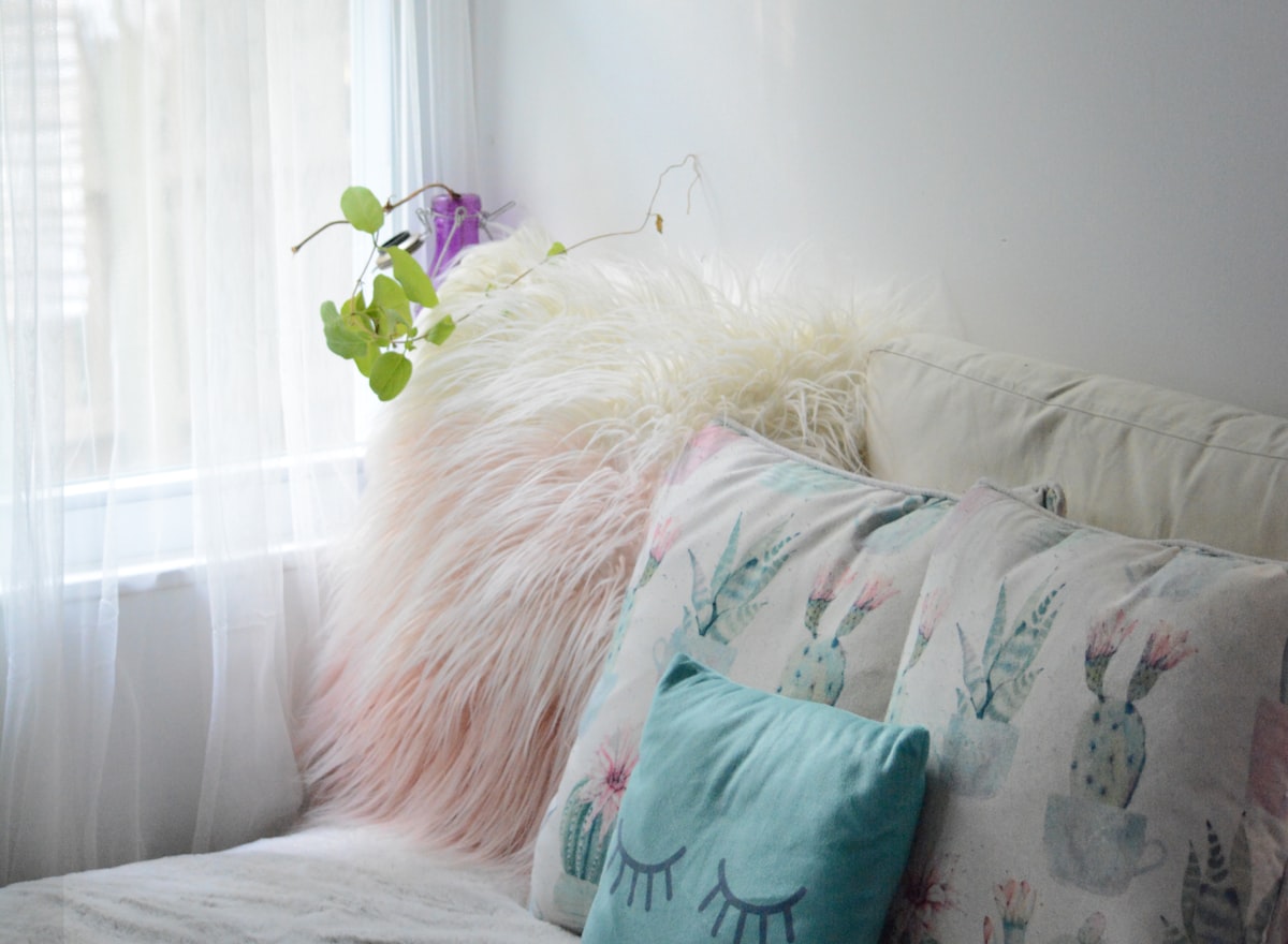 green throw pillow on white couch related to Elevate Your Decor with Faux Leather Valances