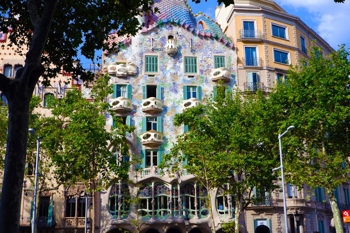 green trees in front of brown concrete building during daytime related to Discover the Charm of Barcelona: Top Bed and Breakfasts to Stay At