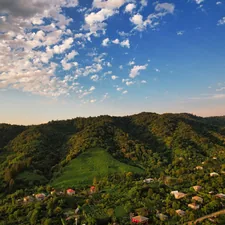green trees on mountain under blue sky during daytime related to Charming Retreats in Georgia