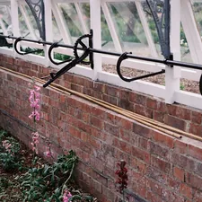 Greenhouse interior with brick wall and plants related to Efficient Gardening with Drip Irrigation for Raised Beds
