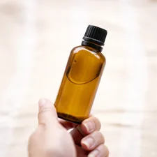 Hand holding amber glass bottle related to Don't Let Bed Bugs Bite: Effective Homemade Repellents
