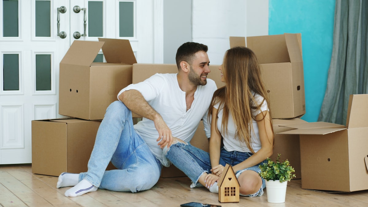 Happy couple sitting on floor in new house indoors related to Revamping Your Home's First Impression: Entryway Laundry Room Ideas
