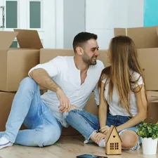 Happy couple sitting on floor in new house indoors related to Revamping Your Home's First Impression: Entryway Laundry Room Ideas