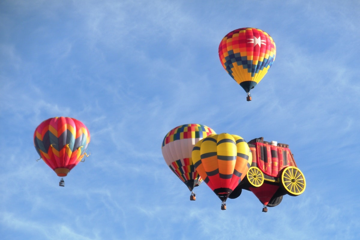 Hot air balloon fly together with a blue sky. related to Elevate Your Nursery with Hot Air Balloon Baby Bedding