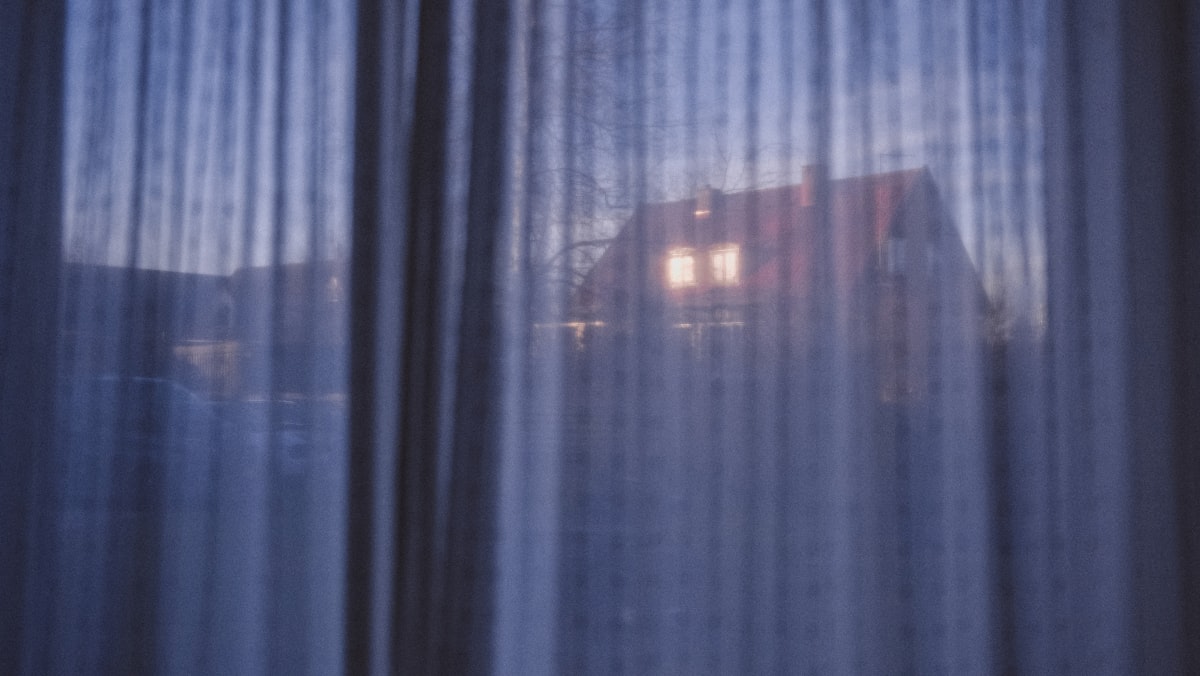 House lights visible through sheer curtains at dusk related to Navy Blue Valance Curtains