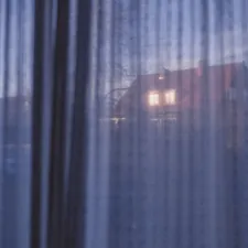 House lights visible through sheer curtains at dusk related to Navy Blue Valance Curtains