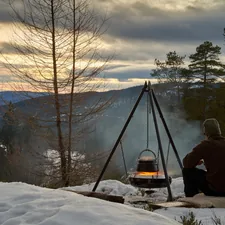 Hungarian goulash is cooking on open fire in the Norwegian woods during winter. View to lake Krøderen during evening light with colorful sunset. related to Discover the Warmth of Chimineas at Home Depot: A Comprehensive Guide to Clay Models