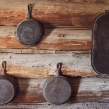 I'll donate this to the internet as a random stock photo of skillets hanging on the wall. I stopped at a small pioneer museum in the very remote town of Fort Rock, Oregon. This is from one of the old pioneer cabins on the property.  related to Rustic Kitchen Valances
