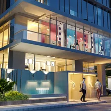 Image Description: This image captures a modern, multi-story building entrance at dusk. The ground floor features large glass windows, revealing a brightly lit interior with a contemporary, open-plan design. The upper floor is also visible through a large glass facade, showcasing colorful, abstract shapes and a vibrant lighting scheme that contrasts with the muted tones of the exterior. Outside, two men are walking towards the entrance, suggesting a residential or commercial setting. The building's exterior is sleek, with a combination of glass, concrete, and what appears to be wooden or metal related to Transform Your Curb Appeal: Outdoor Entryway Ideas to Wow