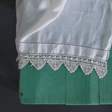 Intricate lace-edged linen on a wooden chair.  related to Shabby Chic Valance: Elegant Window Treatments