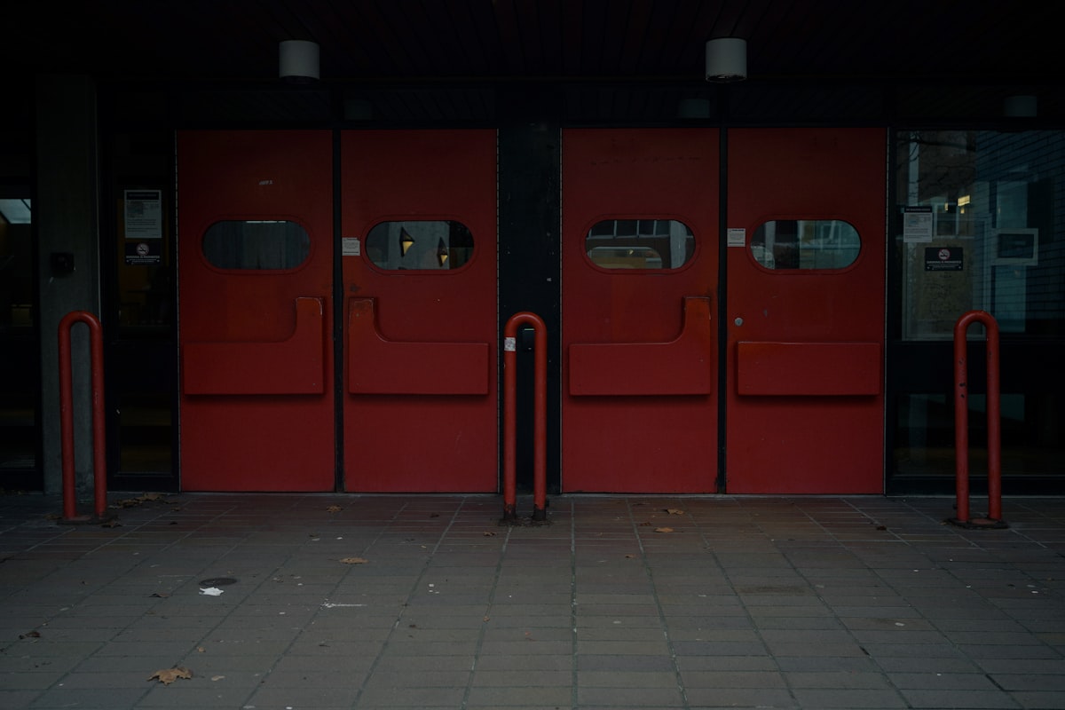 Large red doors with glass panels and metal accents. related to The Evolution of Front Entryway Doors: Design Trends and Features