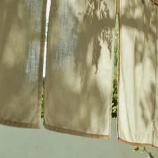 Light filtering through hanging linen curtains outdoors. related to How to Hang Curtains with Valance