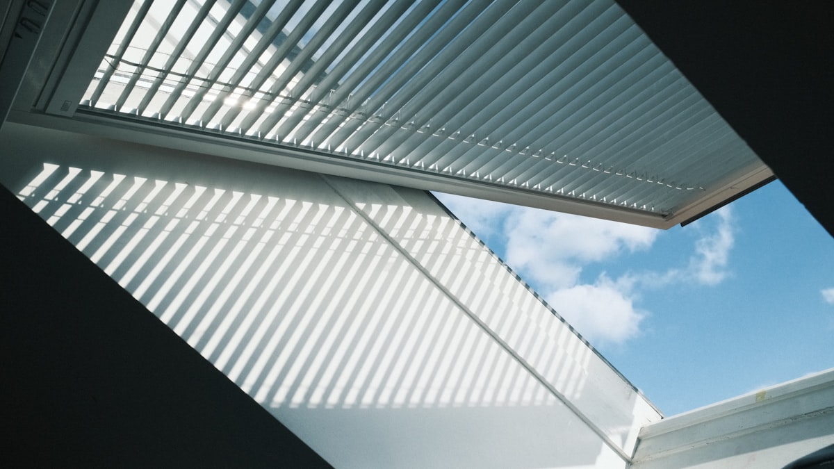 Looking up at a modern, louvered ceiling and sky. related to Valance Over Blinds: Elevate Your Window Treatment Style