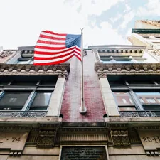low angle photography of waving U.S.A. flag hang on bricks wall related to The Timeless Charm of American Drew Sideboards