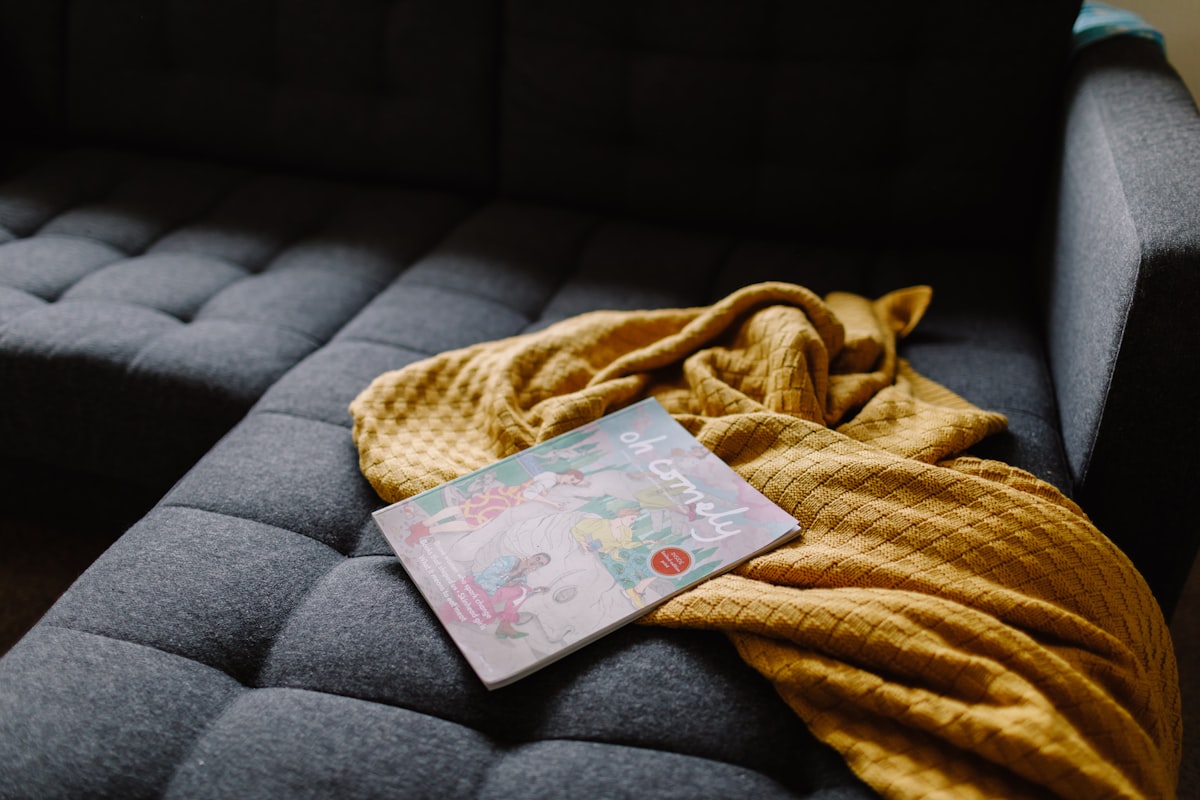 Magazine and rumpled blanket on sofa related to Stylish and Comfortable Baby Bedding Ideas