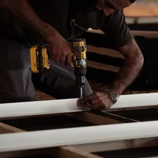 man drilling on a wooden plank using a power drill related to Build a Valance