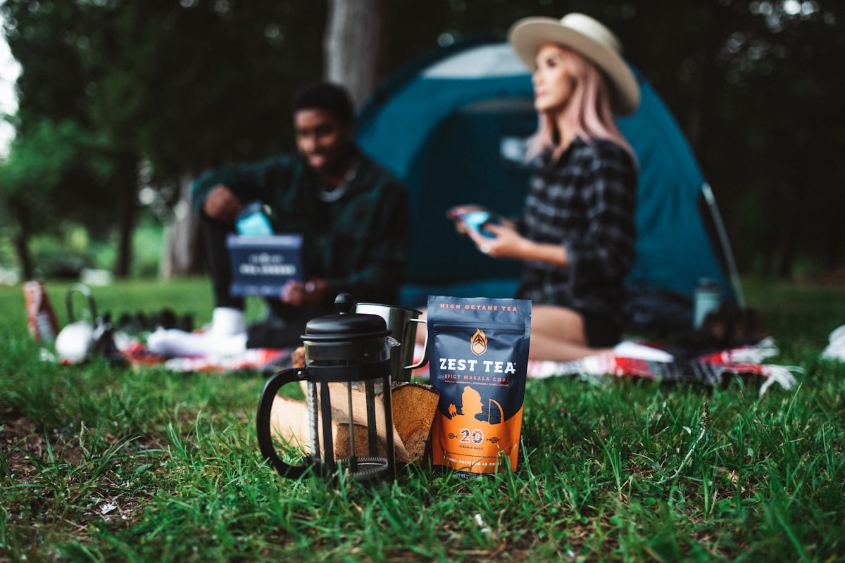 man in black jacket and brown hat sitting on green grass field related to Revolutionizing Your Outdoors: Outdoor Sideboards and Buffets