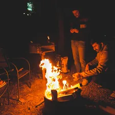 man in black jacket sitting beside fire pit during nighttime related to Warming Up to the Great Outdoors: The Ultimate Guide to Extra Large Cast Iron Chimineas