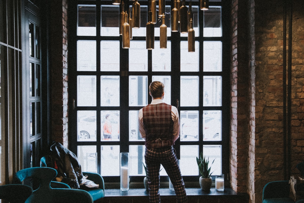 man in blue and white plaid dress shirt standing near window related to The Ultimate Guide to Plaid Valances Window Treatments