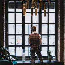 man in blue and white plaid dress shirt standing near window related to The Ultimate Guide to Plaid Valances Window Treatments