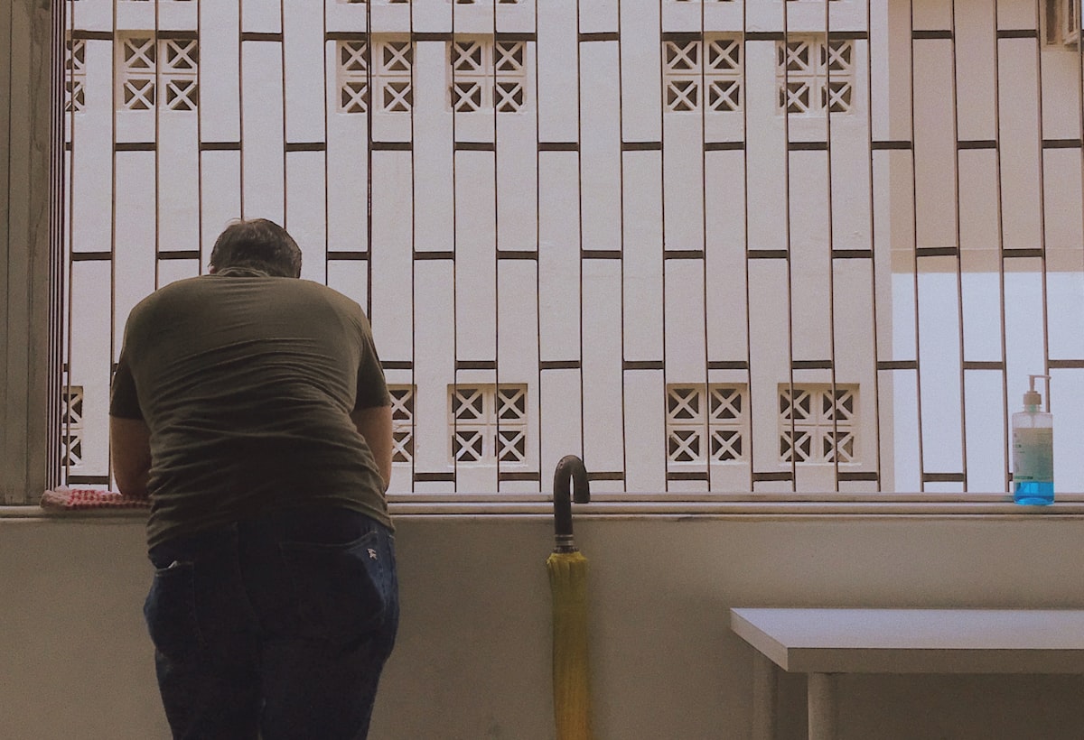 man in gray shirt and blue denim jeans standing near white wooden window related to Making Window Valances