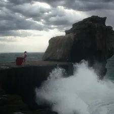 man in red shirt standing on rock formation near sea water during daytime related to Charming Bed and Breakfasts in Blowing Rock, NC: A Cozy Mountain Escape