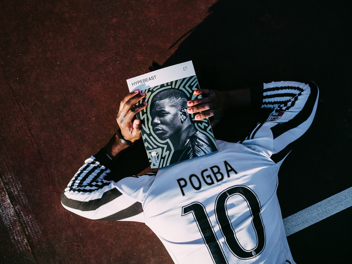 man in white and black adidas jersey shirt holding black and white textile related to The Ultimate Guide to Football Bedding Sets