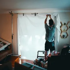 man standing beside white curtain related to Window Valances: Elevate Your Interior Style