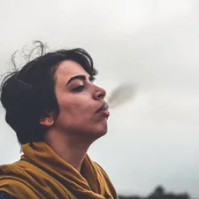 man wearing yellow top smoking related to Breathe New Life into Your Home Decor with the Charisma of a Small Teak Sideboard