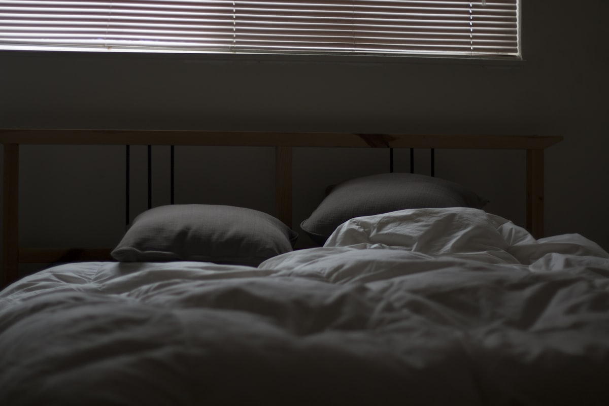 Messy bed and closed blinds related to Decoding the Mystery: What Do Bed Bug Bites Look Like?