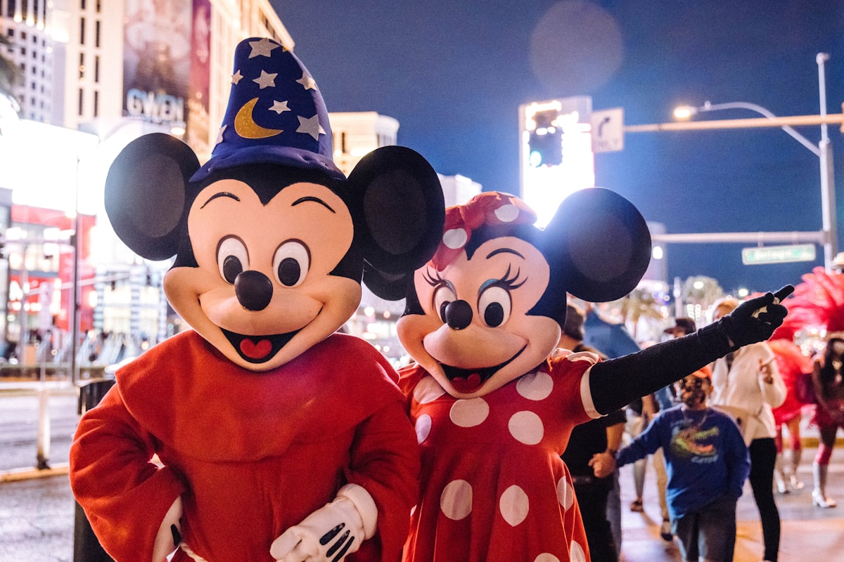 mickey mouse mascot standing near people in mickey mouse costume related to Magical Slumber: The Best Mickey Mouse Bedding for Kids