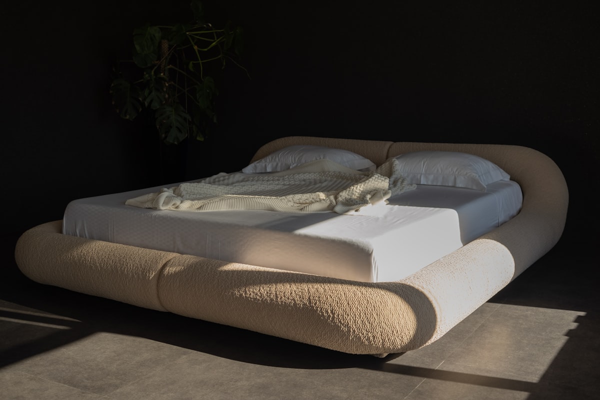 Modern bed with rounded headboard and white linens. related to Luxury Bedding Coverlets