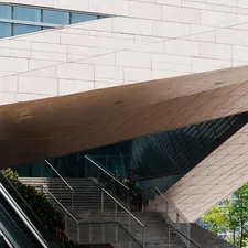 Modern building with angled architecture, escalators, and glass windows. related to Inspiring Front Entryway Design Ideas