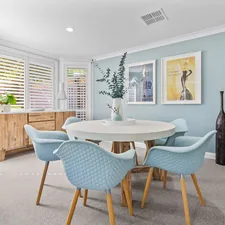Modern dining room with round table and light blue chairs. related to Transform Your Space with the Zayley Twin Bookcase Bed