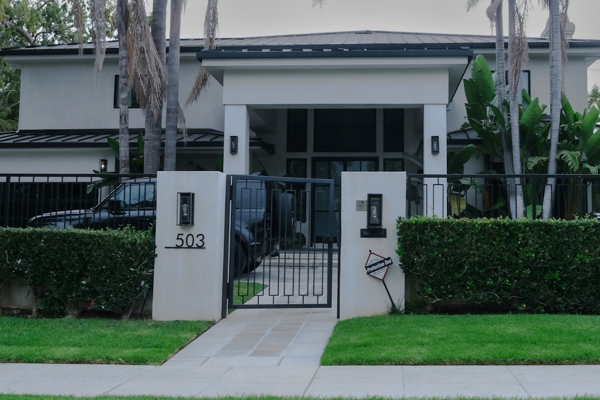 Modern house with manicured hedges and gate. related to Creating a Grand Entrance: A Guide to Entryway Gates and Driveways