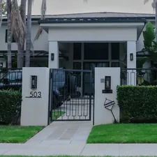Modern house with manicured hedges and gate. related to Creating a Grand Entrance: A Guide to Entryway Gates and Driveways