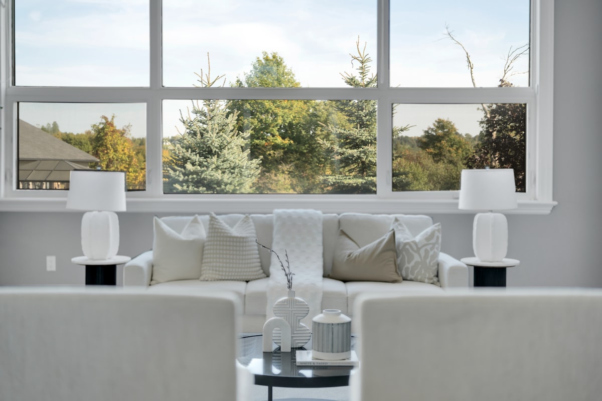 Modern living room with large window overlooking trees related to Valance Styles for Dressing Up Large Windows