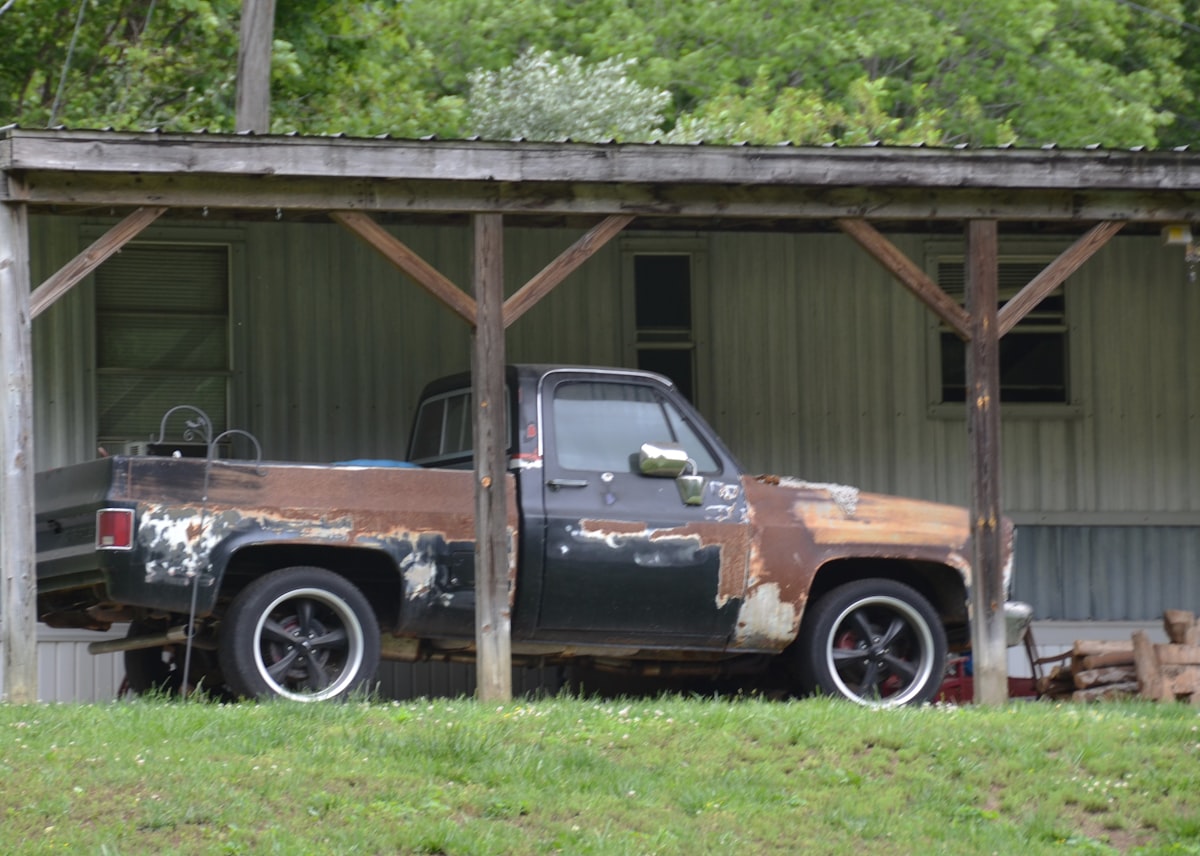 Old mobile home with square body short bed standard cab Chevy truck in some state of being sanded down some years ago??? related to Ultimate Guide to Truck Bed Tool Boxes