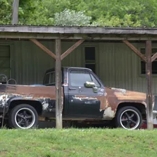 Old mobile home with square body short bed standard cab Chevy truck in some state of being sanded down some years ago??? related to Ultimate Guide to Truck Bed Tool Boxes