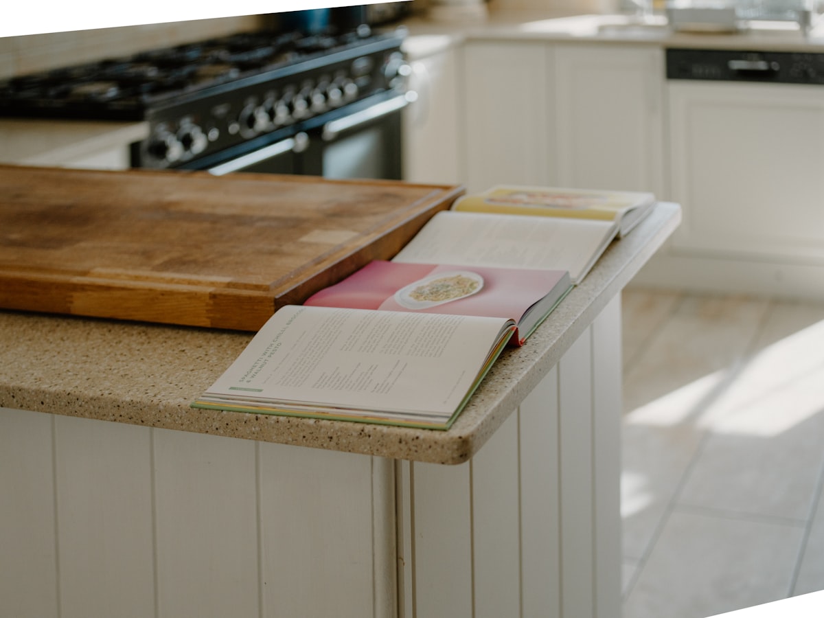 Open cookbooks rest on a kitchen counter. related to Kitchen Sideboards and Buffets: Timeless Elegance and Practicality