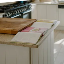 Open cookbooks rest on a kitchen counter. related to Kitchen Sideboards and Buffets: Timeless Elegance and Practicality