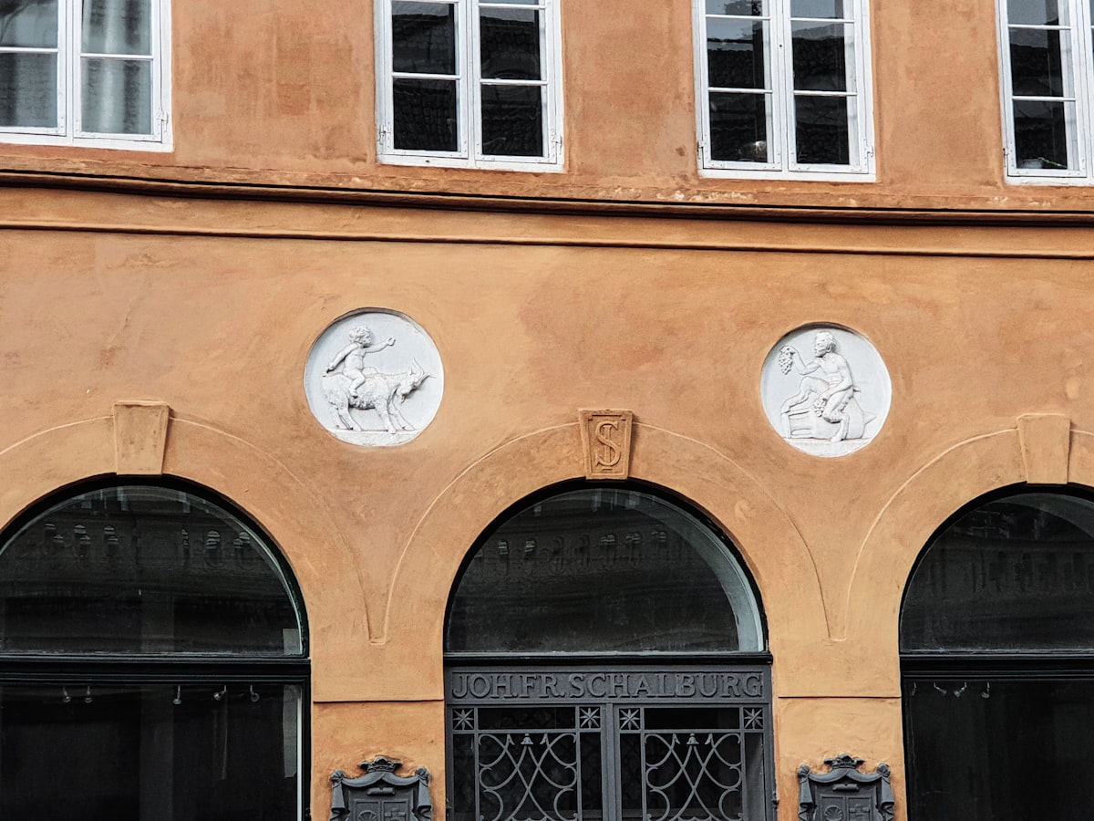 Orange building facade with arched windows and circular reliefs. related to Welcoming Style: Decorating an Entryway