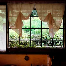 orange window curtains opened near brown wooden chair related to Kitchen Curtains and Valances