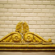 Ornate yellow architectural detail on tiled wall related to The Timeless Beauty of Antique Brass Beds