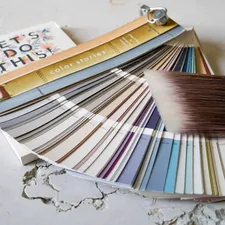 Paint brush and paint colors on table top with notepad related to Welcoming Hues: The Ultimate Guide to Entryway Paint Colors