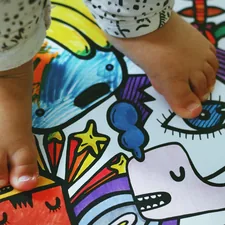 person holding white pink and blue floral textile related to Transform Your Toddler's Room with Superhero Bedding
