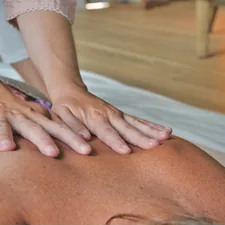 person in white shirt lying on bed related to The Benefits of Massaging Your Muscles at Planet Fitness