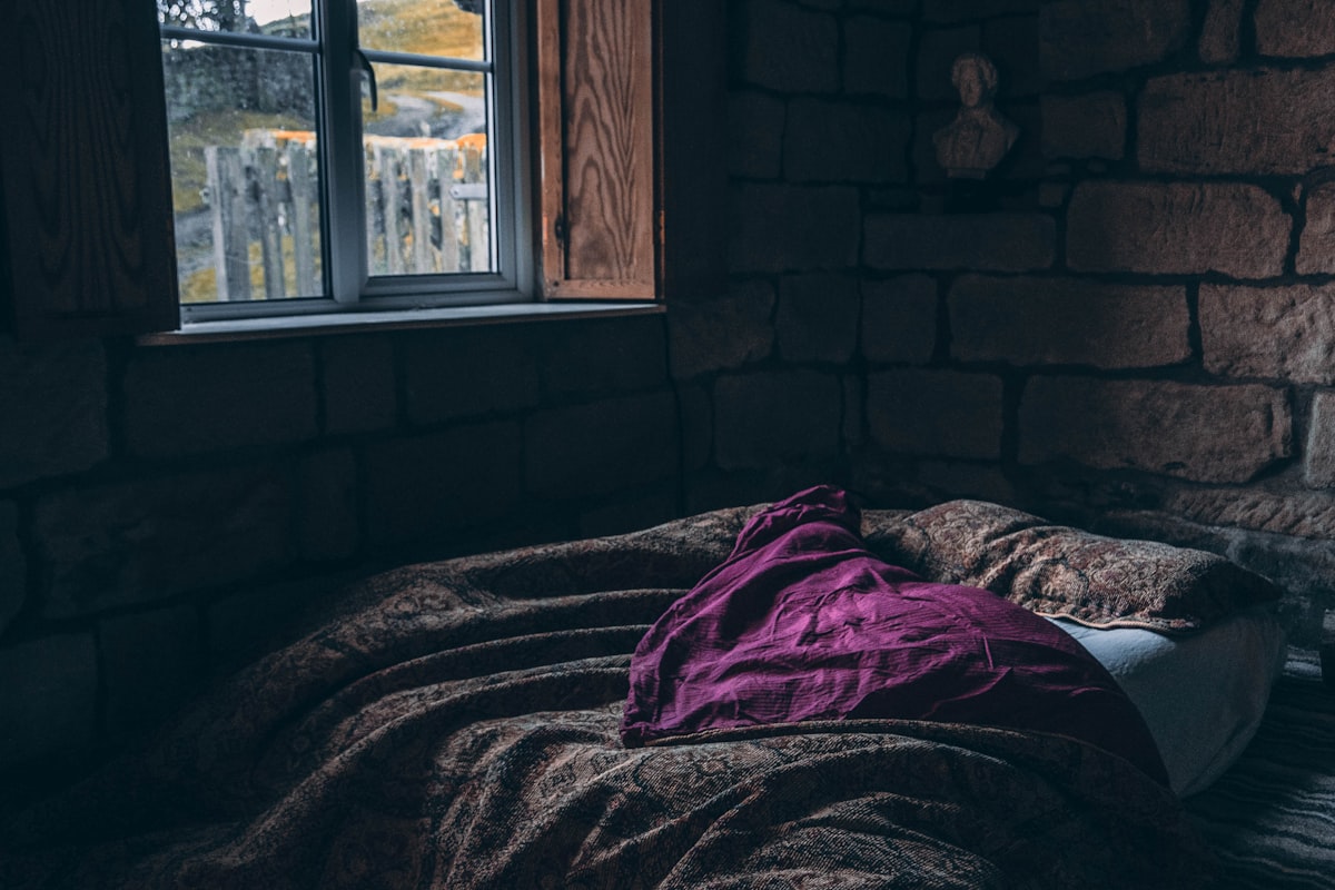 person laying on bed related to Purple Quilts & Coverlets: Warmth & Beauty in Every Shade